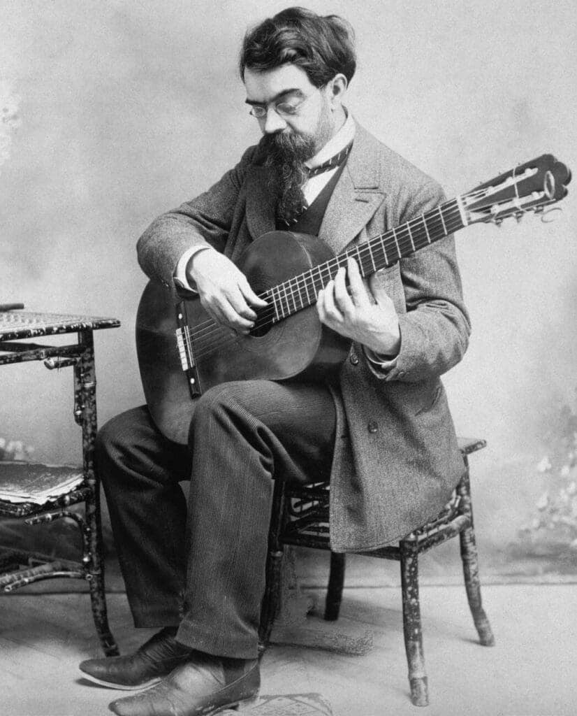 Francisco Tarrega while playing the guitar in the traditional classical setting.