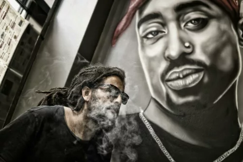 Uomo vicino al ritratto di Tupac Shakur. La musica rap è in stretta connessione con la poesia e spesso ne incarna lo spirito più contemporaneo.